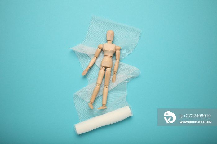 Figure of man with wound and white gauze bandage on blue background. First aid, injury treatment.