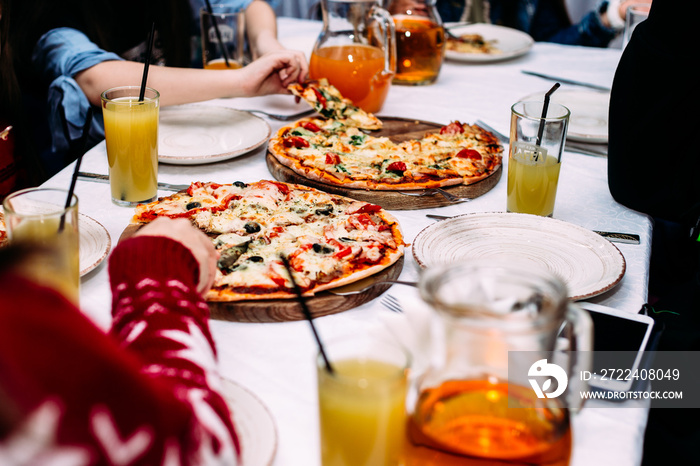 People eat pizza at a table in a cafe