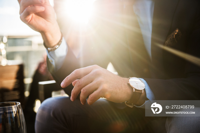 Lifestyle photo of elegant businessmen wearing luxury watch and having dinner in restaurant after succesful working day.