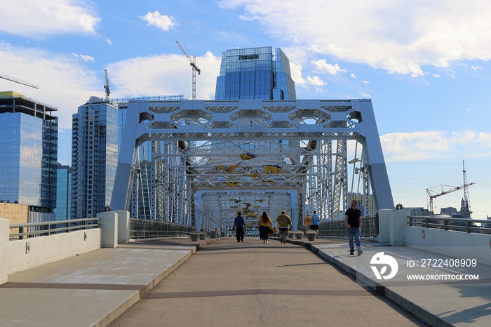 Nashville, Tennessee, United States. Fan of Nashville predators walk on the John Seigenthaler Pedestrian Bridge before hockey match.