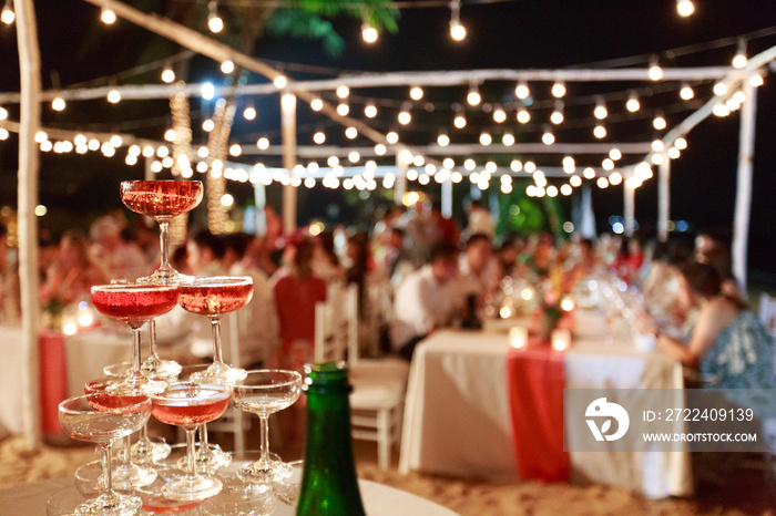 Pyramid from glasses of red wine on wedding party. Close-up of the pink champagne or wine pyramid in ceremony party.