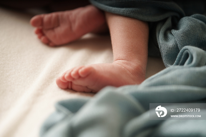 Newborn peel.Newborn Baby’s foot with a blue blanket. Close up a baby’s foot.