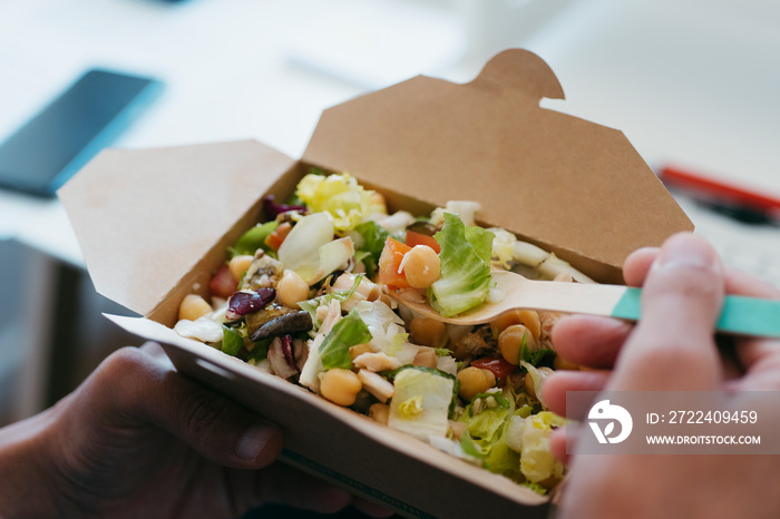 man eats a salad sitting at his desk