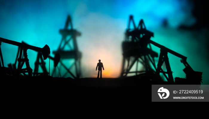 Engineering man standing against beautiful dusky sky of oil refinery plant. Silhouette of a man standing on the road at the oilfield.