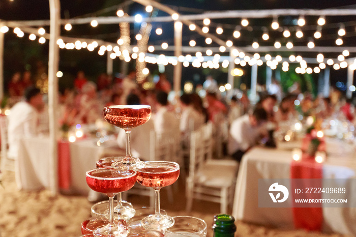 Pyramid from glasses of red wine on wedding party. Close-up of the pink champagne or wine pyramid in ceremony party.