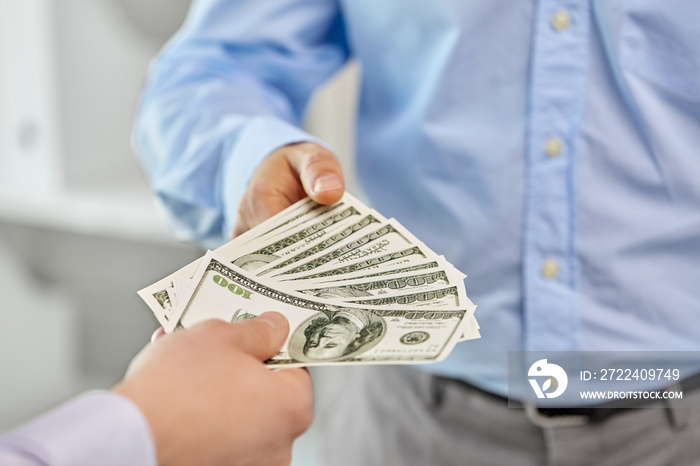 business, people and finances concept - close up of businessmen’s hands holding american dollar money