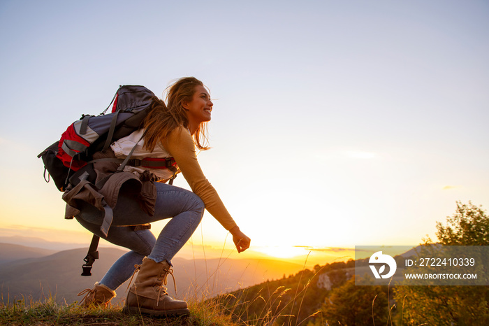 Portrait of happy young woman hiking in the mountains