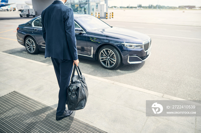 Businessman coming abroad and the car waiting for him