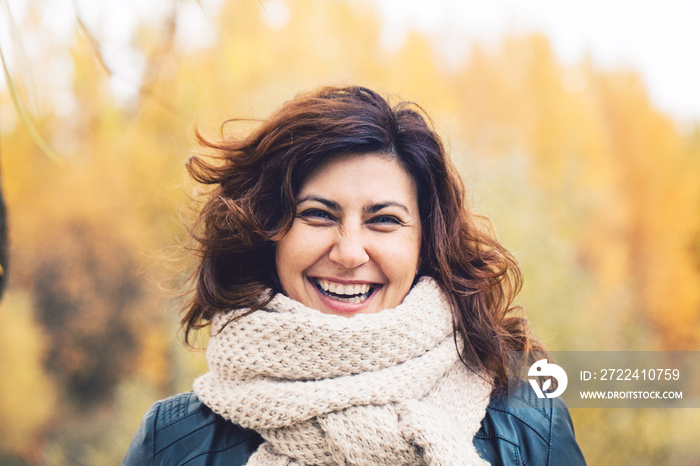 Autumn portrait of cheerful woman in fall park outdoors, portrait. Girl laughing