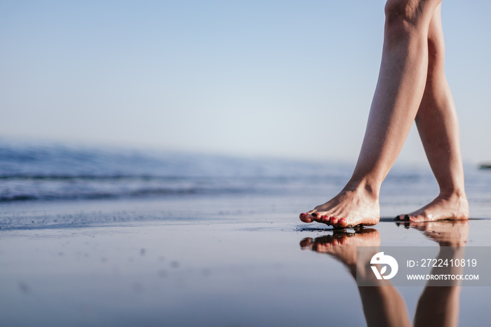 Beach travel concept. Woman Legs on Tropical Sand Beach. Walking Female Feet. Closeup