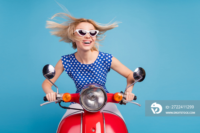 Photo of young cheerful girl happy positive smile ride motorbike transport travel fly hair isolated over blue color background