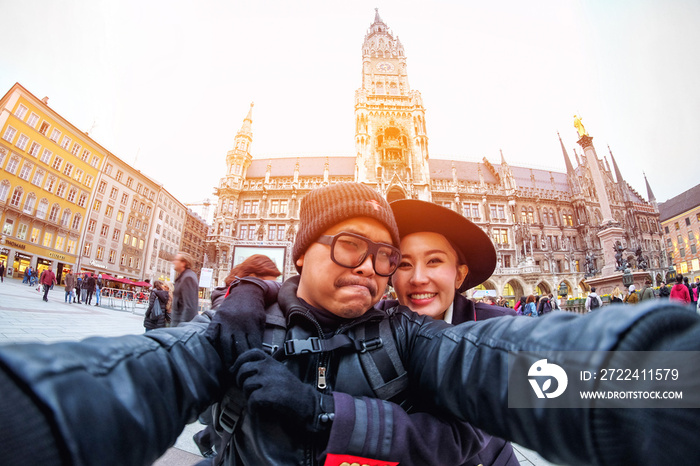 Young Couple Tourists taking selfie with mobile smartphone at the  Marienplatz , a famous landmark in Munich, Germany