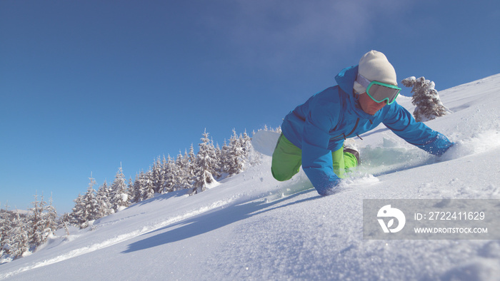 CLOSE UP: Pro snowboarder on scenic ride down mountain falls into fresh snow