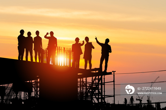 Silhouette of Engineer and worker team on building site, Industrial sector construction site at sunset in evening time