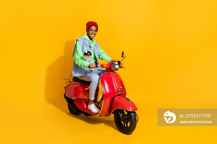 Portrait of attractive cheerful funky girl riding motor bike traveling holiday isolated over bright yellow color background