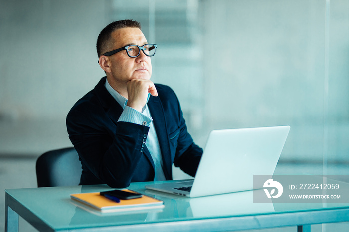 Positive Business Leader Sitting at Desk in modern office