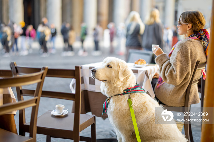 Woman sitting with her dog at outdoor cafe near famous Pantheon temple in Rome. Idea of spending time in Rome. Concept of italian lifestyle and travel