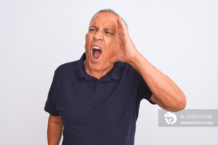 Senior grey-haired man wearing black casual polo standing over isolated white background shouting and screaming loud to side with hand on mouth. Communication concept.