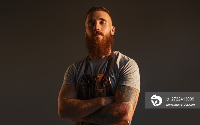 Confident male hairdresser with crossed arms