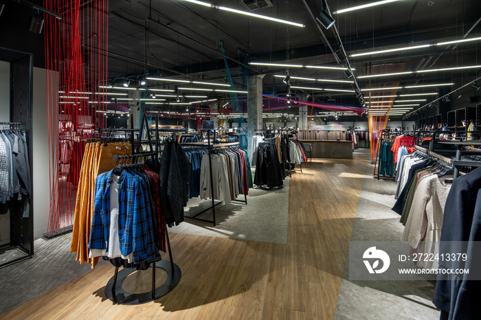 Modern clothes shop with large selection of different wear and shoes