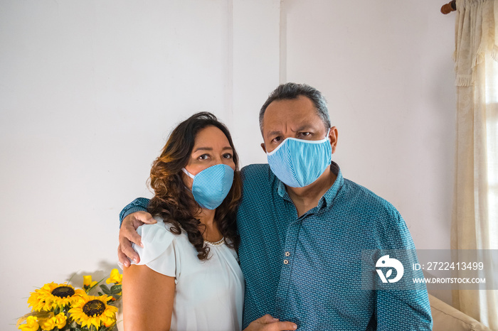 Older couple with medical mask in their living room