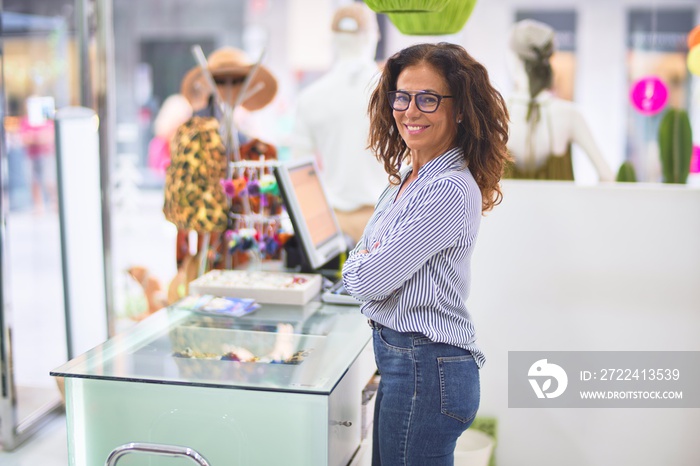 Middle age beautiful clothes shop owner woman smiling happy and confident waiting customers at counter