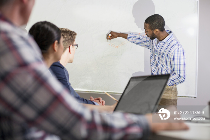 coworkers watching presentation on whiteboard