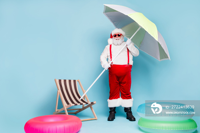 Full length body size view of his he nice cool fat cheerful Santa traveler carrying umbrella beach pool party tourism isolated over blue turquoise pastel color background