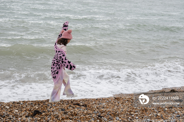 Girl walking on beach on cloudy day