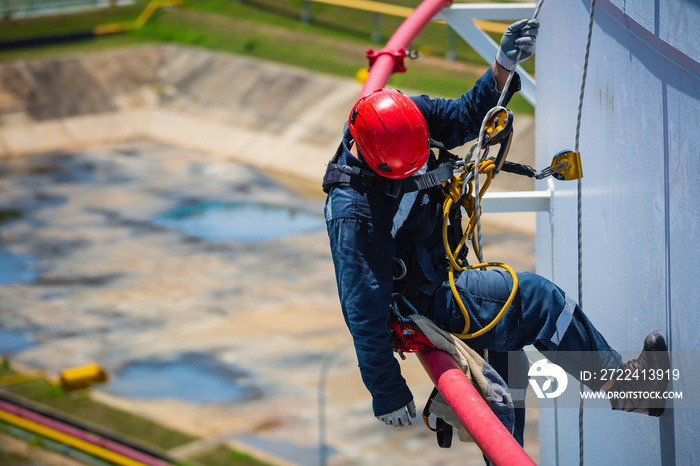 Focus male worker down height tank roof rope access safety inspection of thickness storage tank gas