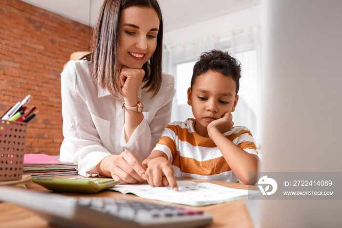 Little African-American boy studying Mathematics with tutor at home