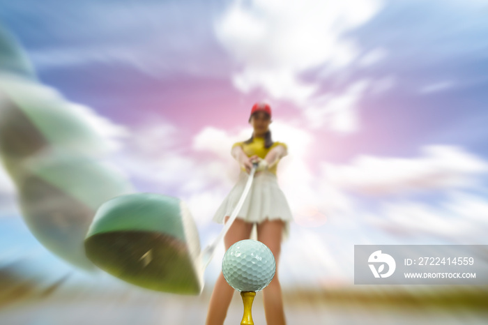 golf ball on wooden tee being hit by woman golf player on tee off to fairway destination in the golf course, motion blur of wood driver going ti impact a golf ball