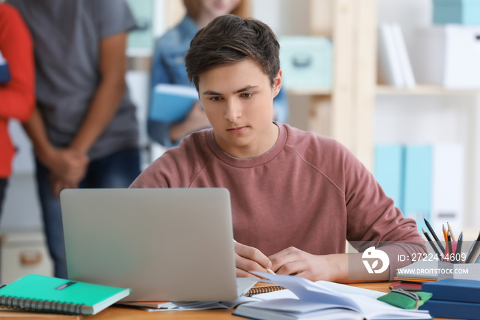 Teenage boy doing homework at table