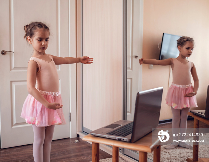 Young ballerina practicing classic choreography during online class in ballet school, self-isolation