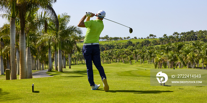 Golfer on a golf course, ready to tee off. Golfer with golf club hitting the ball for the perfect shot.