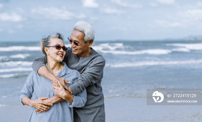 Asian senior couple or elderly people walking and siting at the beach on their weekend vacation holiday. Retirement vaction concept.