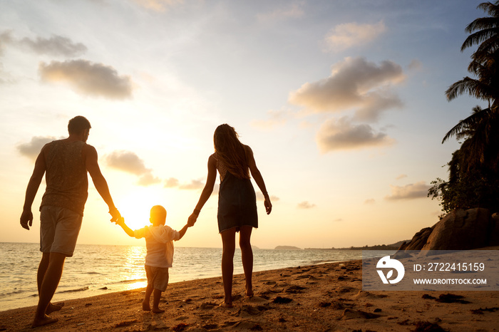 family walk along the beach at sunset with his son, silhouette