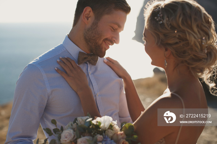 Romantic fairy tale couple of newlyweds hugs and kisses at sunset.