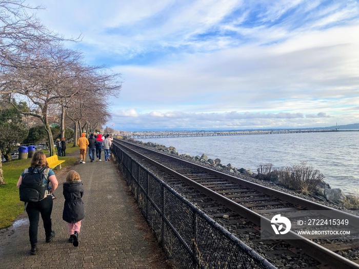 People admiring and walking along the shoreline with beautiful views of White Rock, Surrey, British Columbia, Canada.