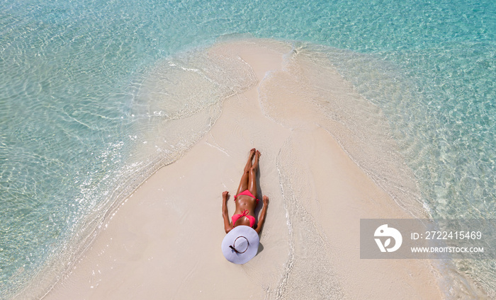 Luftaufnahme einer sich sonnenden, attraktiven Frau im Bikini am Strand der Malediven