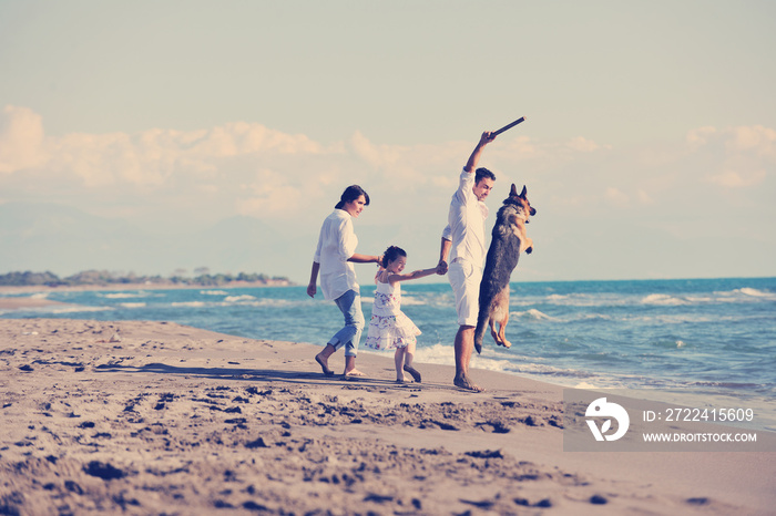 happy family playing with dog on beach