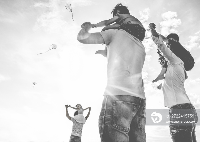 Fathers with children flying with kites and having fun on the beach - Black and white editing