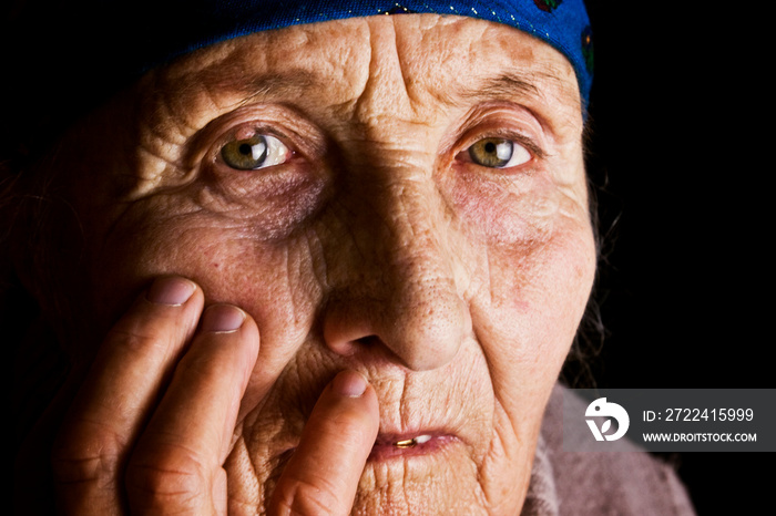 The face of an old grandmother close-up. Wrinkles of the grandmother. Portrait of an old woman