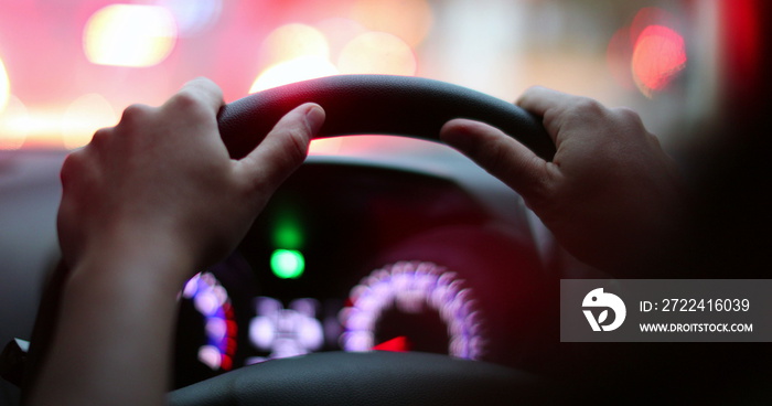 Hands holding steering wheel stopped in traffic. Close-up hand waiting in traffic.