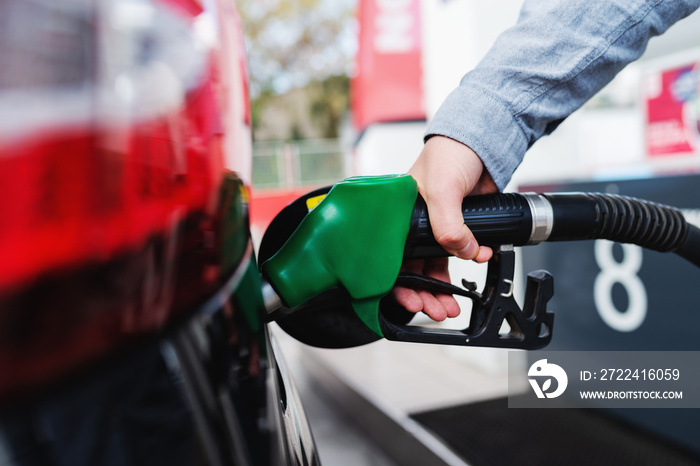 Close up of man refilling tank on his car on the gas station.