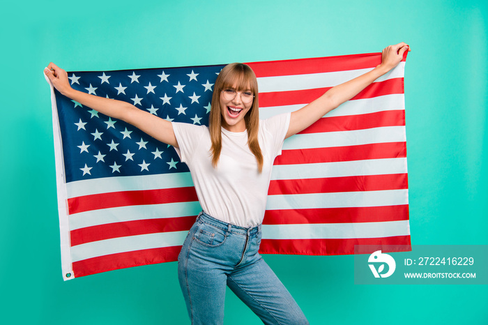 Close up photo beautiful she her lady arms hands hold spread big american flag yelling festive mood crazy carefree weekend vacation wear specs casual white t-shirt isolated teal green background