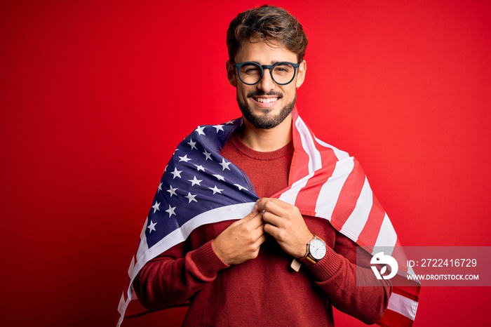 Young man wearing glasses and United States of America flag over isolated red background with a happy face standing and smiling with a confident smile showing teeth