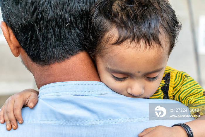 Asian refugee with his sick child at a border