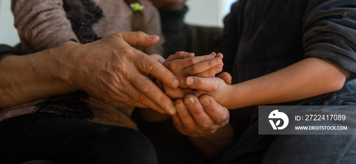 Family bonding. grandfather and child holding hands together, closeup view. Panorama