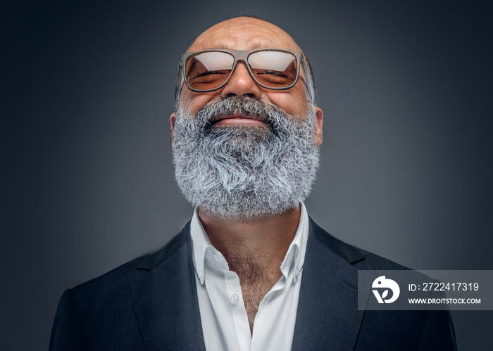 Studio shot of handsome senior man businessperson dressed in stylish coat and sunglasses.